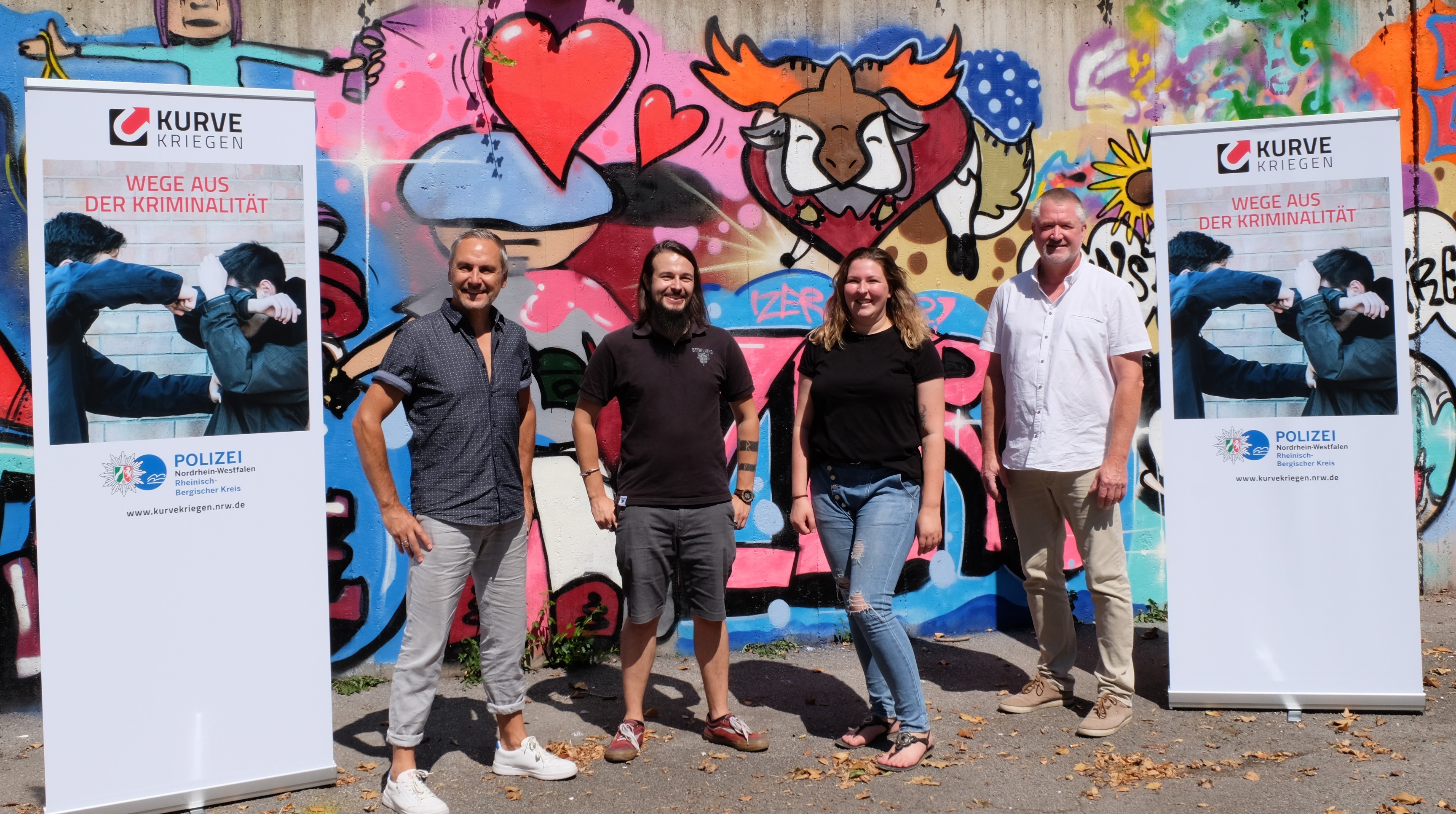 Teilnehmer des Patenschaftstreffen vor einer Graffiti-Wand
