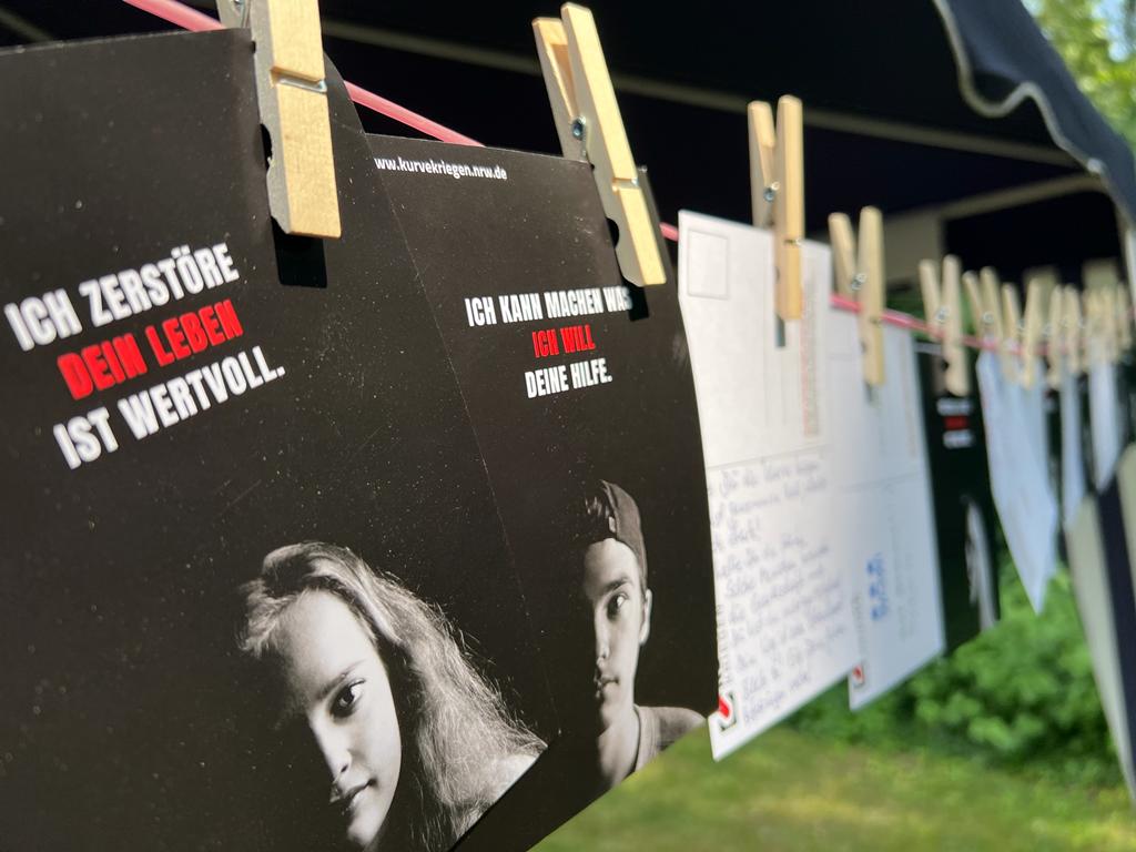 Postkarten an einer Wäscheleine am Stand von Team Kurve kriegen Bonn