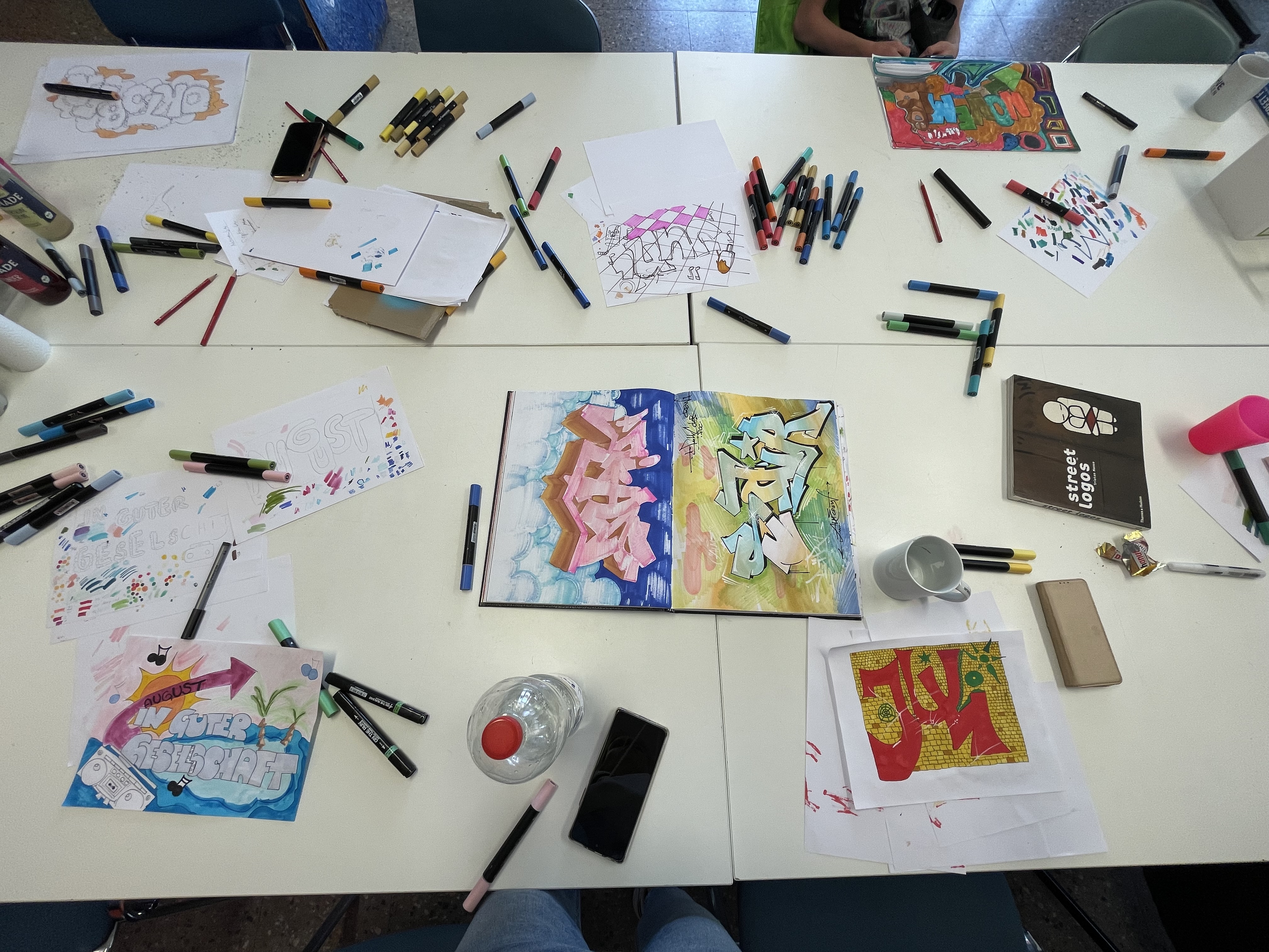 Ein Tisch mit Zeichnungen und vielen Stiften